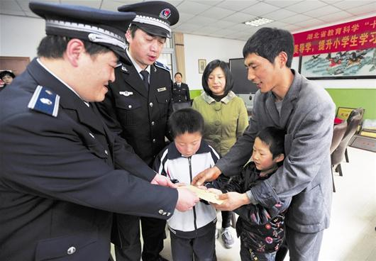 　洪山區(qū)城管隊(duì)員將捐款送至徐軍勝（右一）及小安康（右二）手中