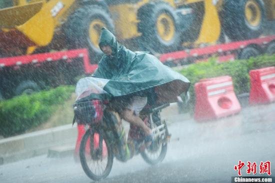 圖為南寧市民冒雨出行。中新社發(fā) 馮抒敏 攝