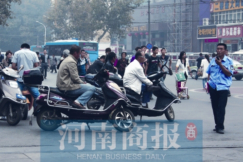 　火車站廣場(chǎng)北側(cè)，幾輛摩的正在等客