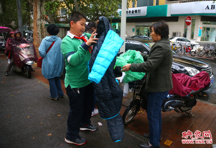 學(xué)校門口，家長給孩子帶來了御寒的厚衣服。