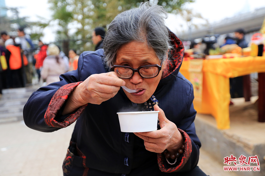 紫荊山施粥點老奶奶領(lǐng)到熱騰騰的臘八粥后馬上品嘗起來