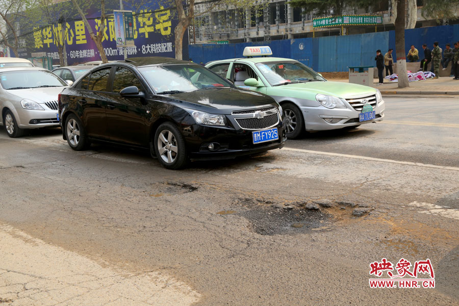 南陽(yáng)路上汽車?yán)@坑而行