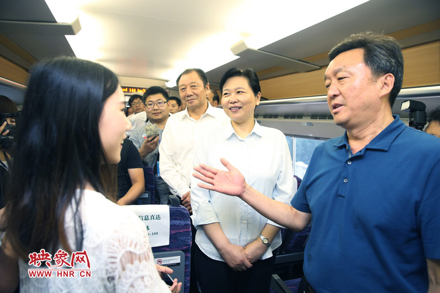 6月26日,首發(fā)的鄭焦動車上,副省長王艷玲(右二)和乘客交流