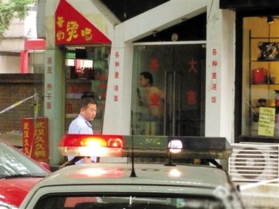 闖入面館的持刀男子與趕來的民警隔著玻璃門對峙，后店內(nèi)一名女童被其劫持。網(wǎng)友供圖