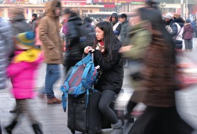 春運(yùn)首日，北京站客流量明顯增多，一名女孩在人流中等待進(jìn)站。