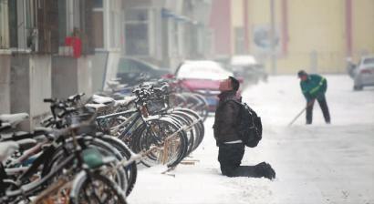 小伙子跪在樓前，一直抬頭看著樓上。 孫立國/攝