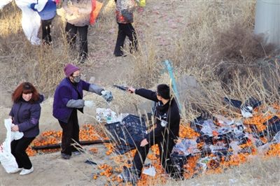 1月4日，連霍高速蘭州市榆中縣和平鎮(zhèn)段，一名警察舉著槍驅(qū)散哄搶橘子的村民。圖/CFP