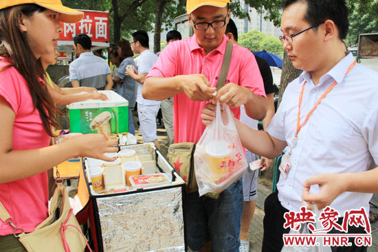 圖為徐貴雨和一名勤工助學(xué)的學(xué)生在街頭義賣快餐。