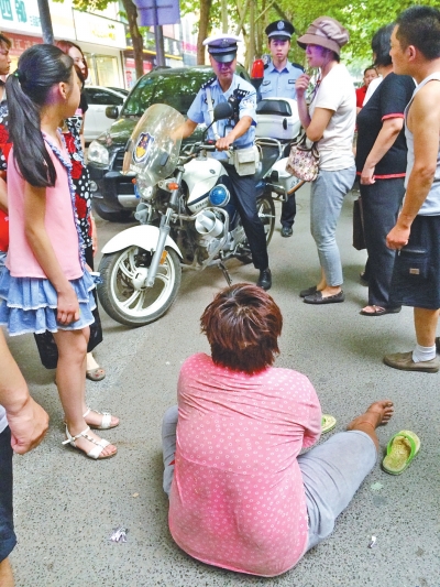 在鄭州優(yōu)勝南路東三街交叉口向東100米處，一名短發(fā)中年女子平躺在路南快車道上，身旁還有一只掉落的拖鞋