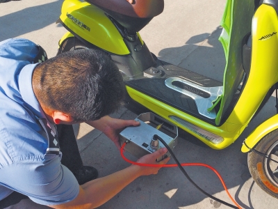 民警手持打碼機(jī)正對(duì)電動(dòng)車車架刻編碼