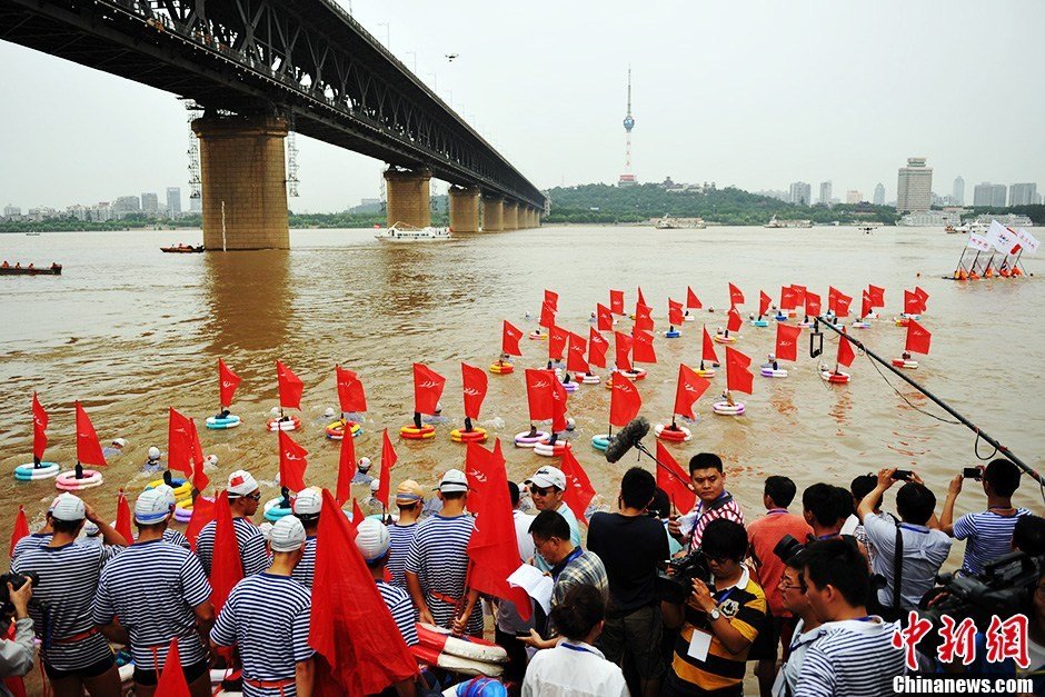 圖為江面上的橫渡方隊(duì)里的選手們劈波斬浪。中新社發(fā) 張暢 攝