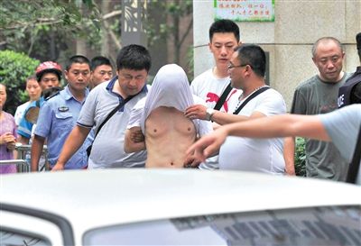 昨日，成都警方抓捕時與毒犯發(fā)生槍戰(zhàn)。一名男犯罪嫌疑人被警方押出。