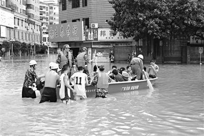 18日，廣東省清遠市陽山縣縣城,消防官兵合力推動沖鋒舟，轉(zhuǎn)移被困學(xué)生。新華社發(fā)