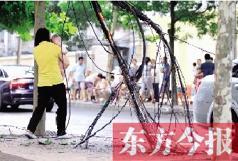 被雷電擊斷的高壓線和通訊電纜垂在地面上