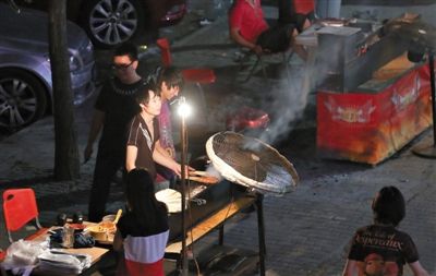 7月4日，青年路國(guó)美第一城小區(qū)附近的夜市臨街露天燒烤攤。