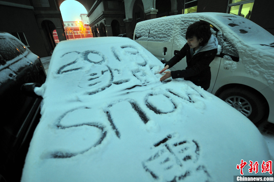 11月18日，行人在車輛的積雪上涂鴉。