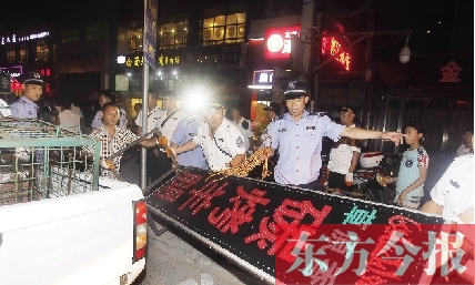 7月8日晚，鄭州市商城路一家占道經(jīng)營的攤販招牌被執(zhí)法隊(duì)員“登記保存”