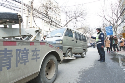 聯(lián)合執(zhí)法人員將市民舉報(bào)的違法占道經(jīng)營(yíng)車輛拖走暫扣