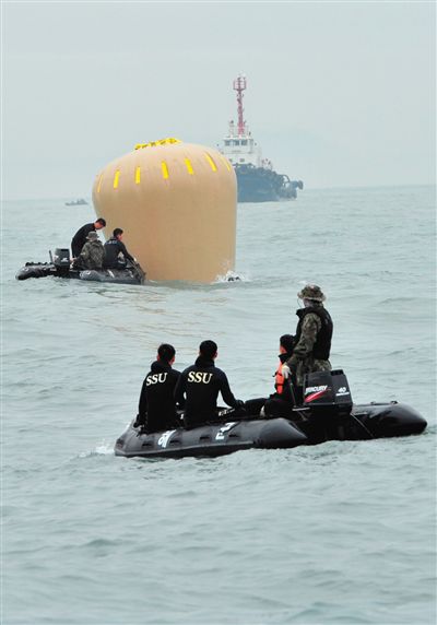 18日，搜救人員準備將氣囊捆綁到沉沒客輪上。