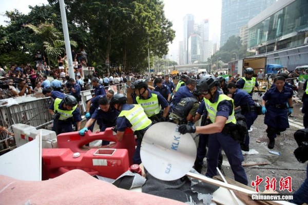 10月14日，警方清除金鐘道障礙物。大批警員在金鐘道現(xiàn)場清拆障礙物。部分警員戴上頭盔將障礙物移走。