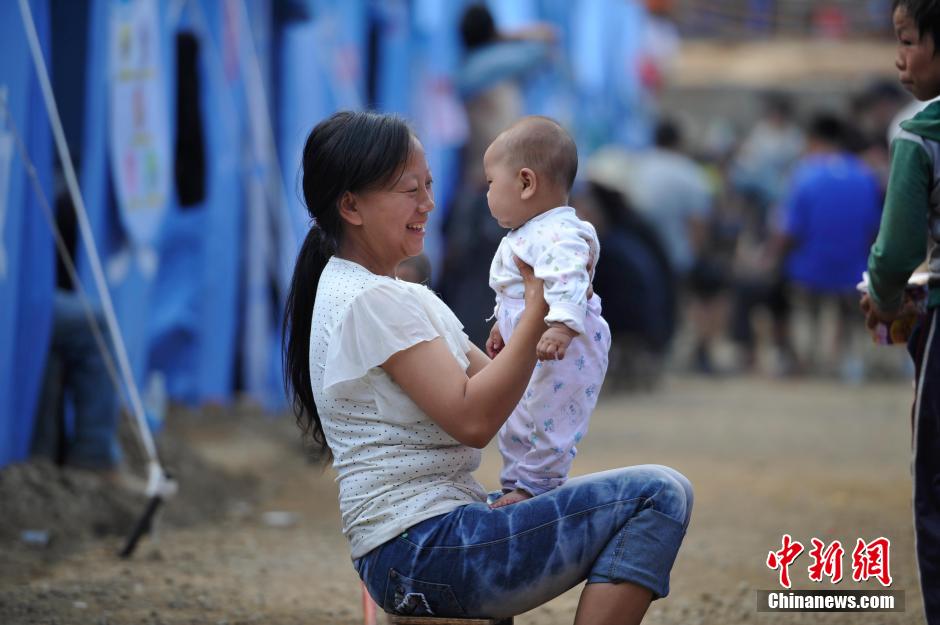 8月6日，一名年輕的母親在和孩子玩樂。