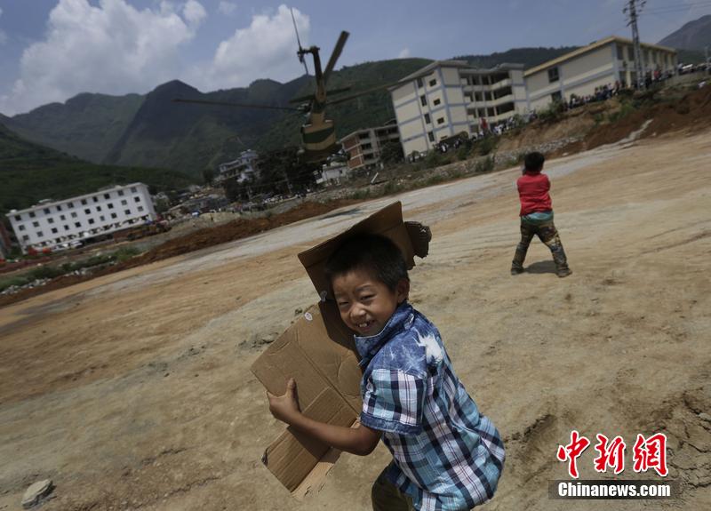 云南省昭通市魯?shù)榭h發(fā)生6.5級地震。幾個孩子在直升機(jī)降落的平地上玩耍。