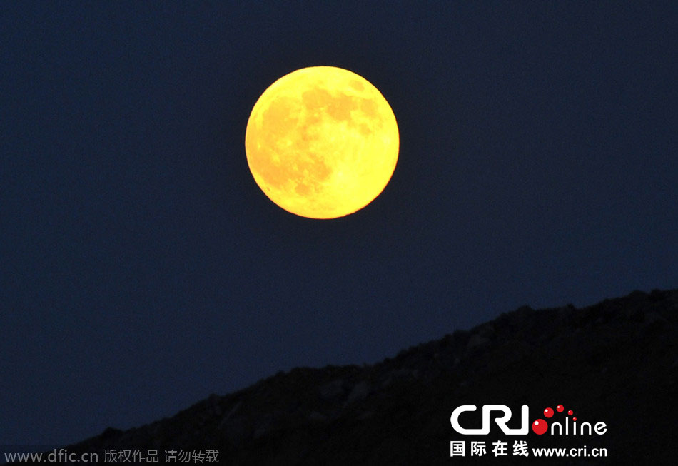 8月10日晚，一輪金燦燦的大月亮在遼寧省大連市東方升起。圖片來(lái)源：劉德斌/東方IC