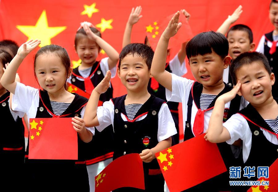  9月28日，安徽淮南市直機關(guān)幼兒園的小朋友在國旗前唱《國歌》，慶祝祖國65周歲生日。