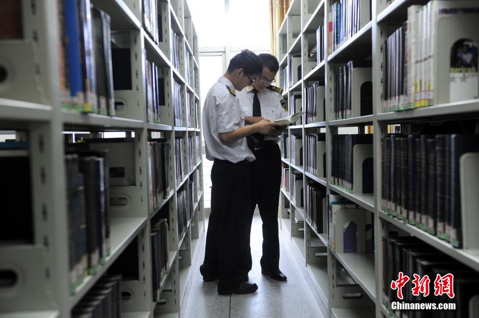 5月8日，武漢輕工大學(xué)保安吳濤與江力在圖書館交流學(xué)習(xí)。中新社發(fā) 張暢 攝