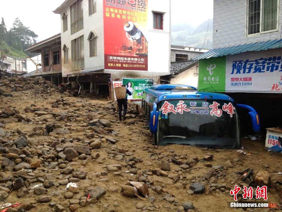 圖為山洪泥石流導沖進鄉(xiāng)鎮(zhèn)街道，導致客車被埋。