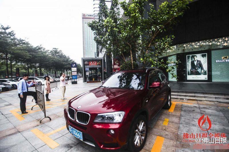 一輛停在停車位上的寶馬轎車，被墜落的樹枝砸中，樹枝徑直插入車內(nèi)，現(xiàn)場(chǎng)引發(fā)不少市民圍觀拍照。