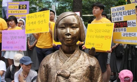 7月2日，在韓國首爾的日本駐韓國大使館前，民眾在慰安婦少女像旁手持標(biāo)語參加抗議活動(dòng)。