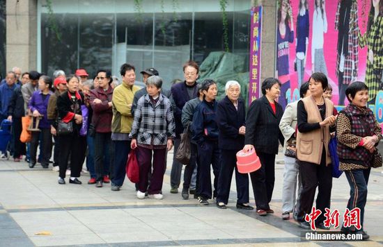 圖為10月28日，在江西九江市一家羊絨皮草服裝服飾博覽會(huì)現(xiàn)場(chǎng)，老人們正在頂著寒風(fēng)排隊(duì)等待領(lǐng)取10元代金劵。