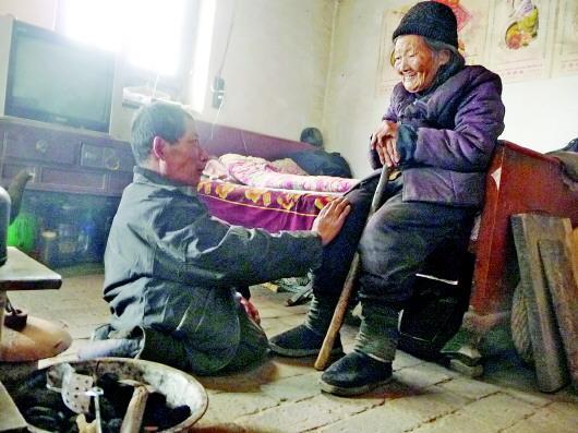 52歲的劉蘭山每天靠爬行照顧90歲的老母親。孫國祥 攝