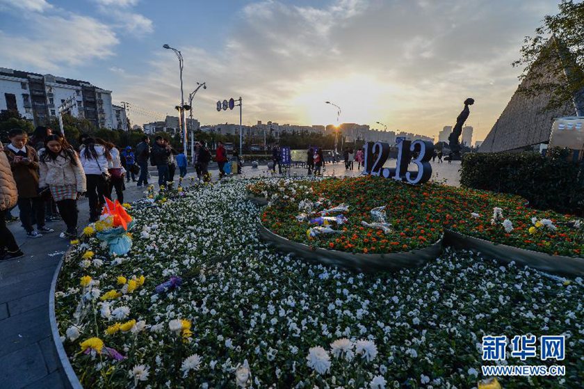 12月14日,觀眾在侵華日軍南京大屠殺遇難同胞紀念館前的“12·13”花壇上擺放鮮花祭奠遇難同胞。新華社記者 沈鵬 攝